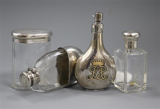 A silver perfume flask with monogram, two silver-mounted toilet bottles and a silver-mounted glass hip flask